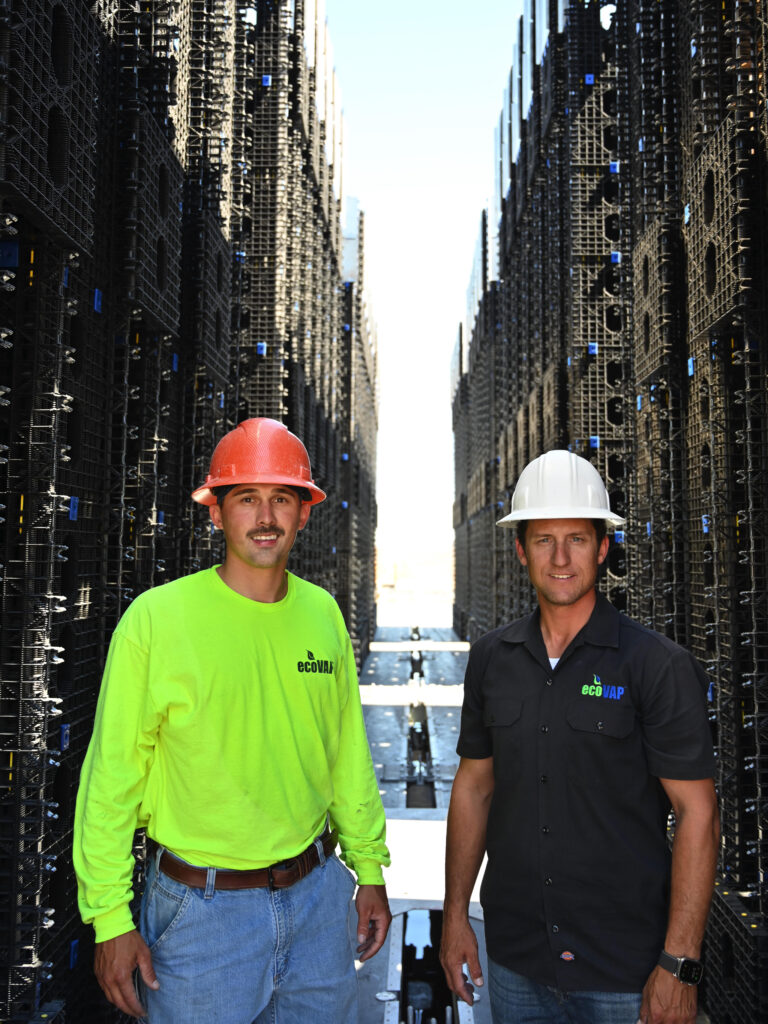 Nick and Brant wearing hard hats on site, standing in front of the Ecovap evaporative matrix.